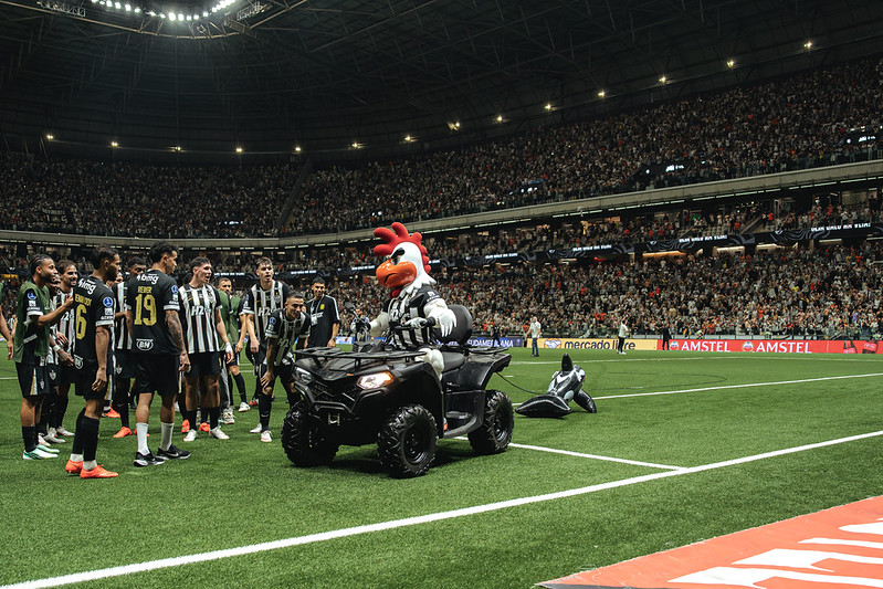 Galo Doido (mascote do Atlético-MG) pilotando um quadriciclo com a Baleia (mascote do Santos) amarrada